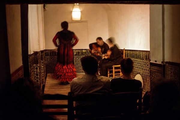 Tiny Triana flamenco room in Seville with a few rows of chairs close to the boards